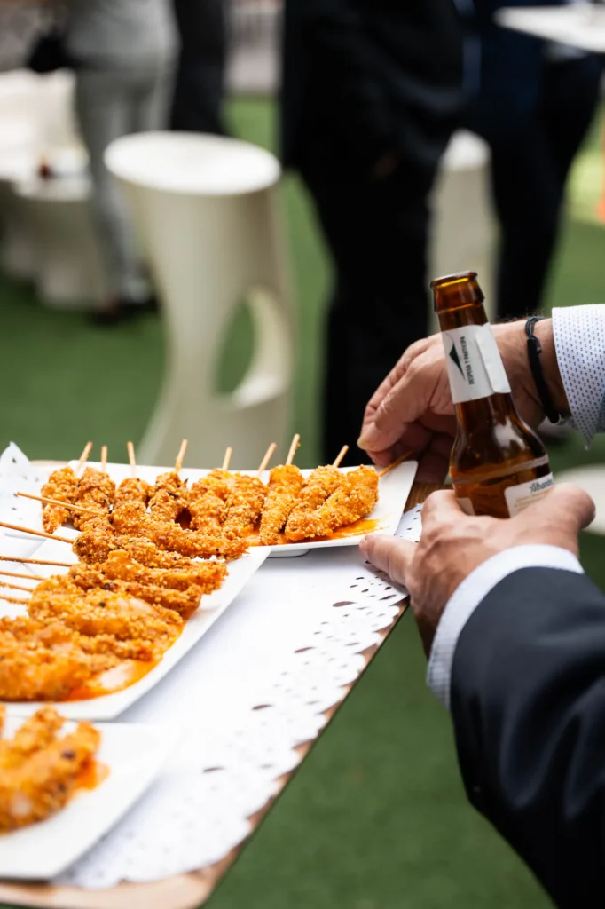 Invitados cogiendo aperitivos crujientes durante el cóctel en el jardín
