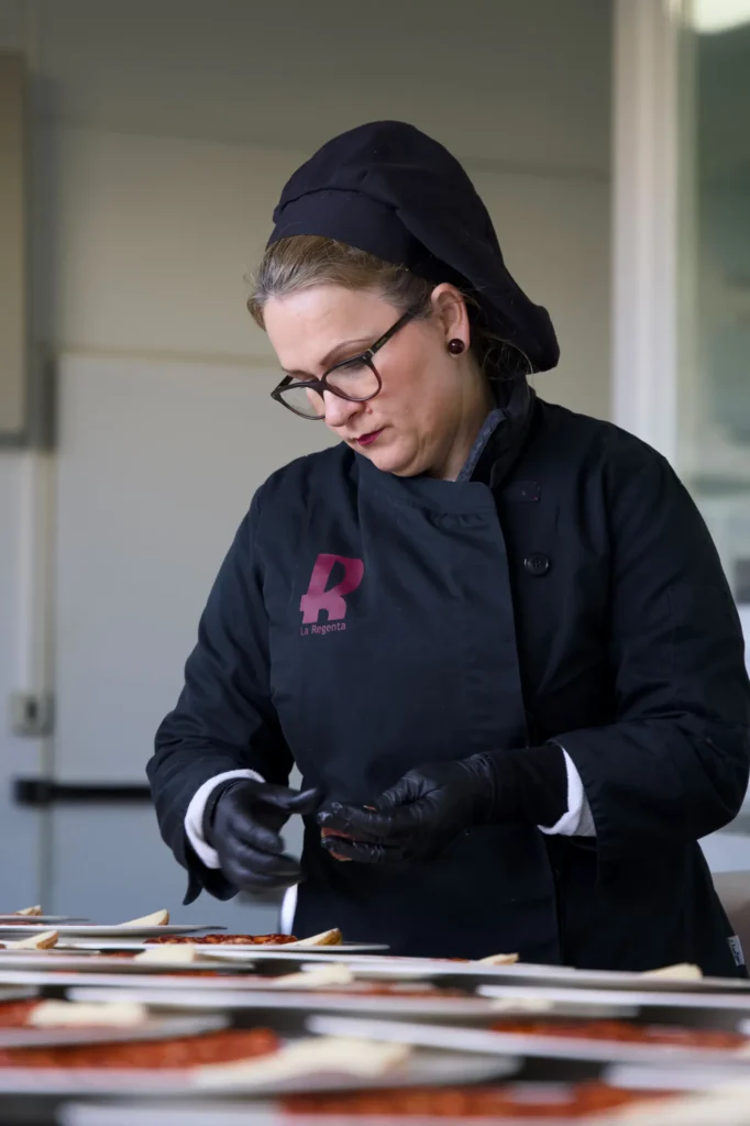 Cocinera emplatando en la cocina de La Regenta antes de un banquete