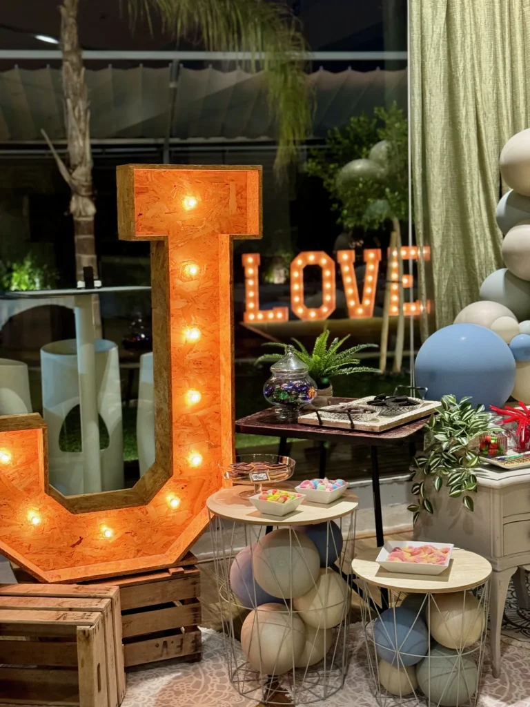 Letras luminosas LOVE y decoración con globos en tonos azules en una boda