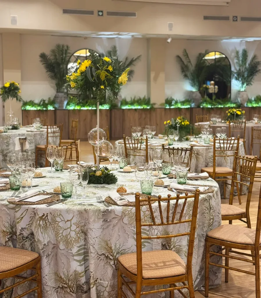 Mesas redondas montadas en el salón de banquetes con decoración vegetal