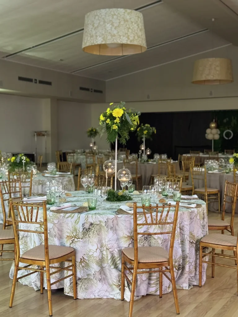 Salón con lámparas de fibra natural y mesas redondas montadas para un evento