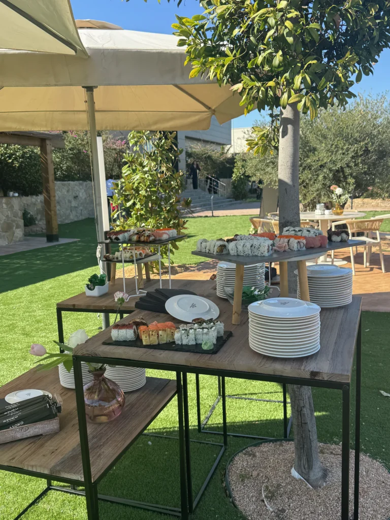 Mesas de buffet para el cóctel bajo una sombrilla en el jardín