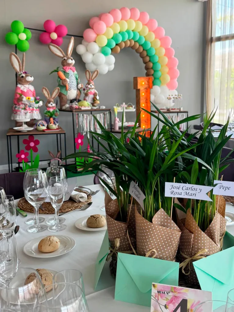 Mesa de comunión con plantas de regalo para los invitados y decoración de conejitos