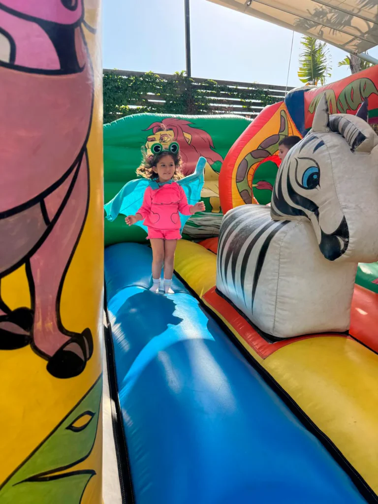 Niña jugando en el castillo hinchable de la animación infantil de una comunión en La Regenta