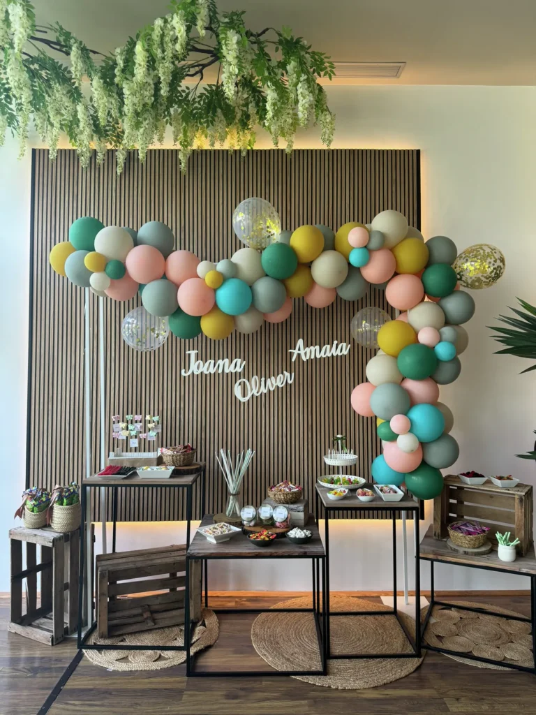 Photocall de comunión con guirnalda de globos y mesa de dulces