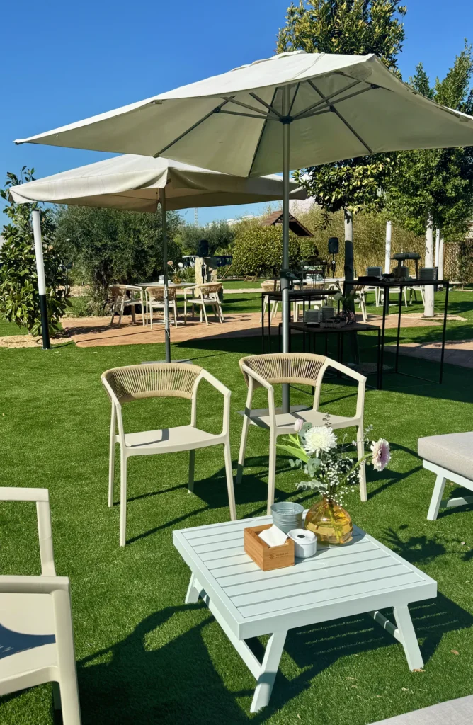 Zona chill out con sombrillas y mesas bajas en el jardín de La Regenta
