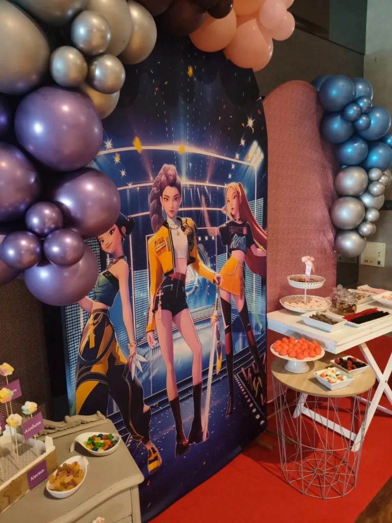 Mesa de dulces de comunión con temática K-Pop, globos metalizados y alfombra roja
