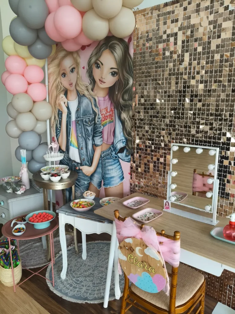 Rincón de dulces y tocador con espejo de luces en una comunión con temática Top Model